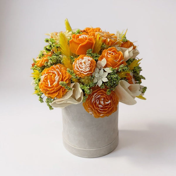 orange candle in box with dry flowers